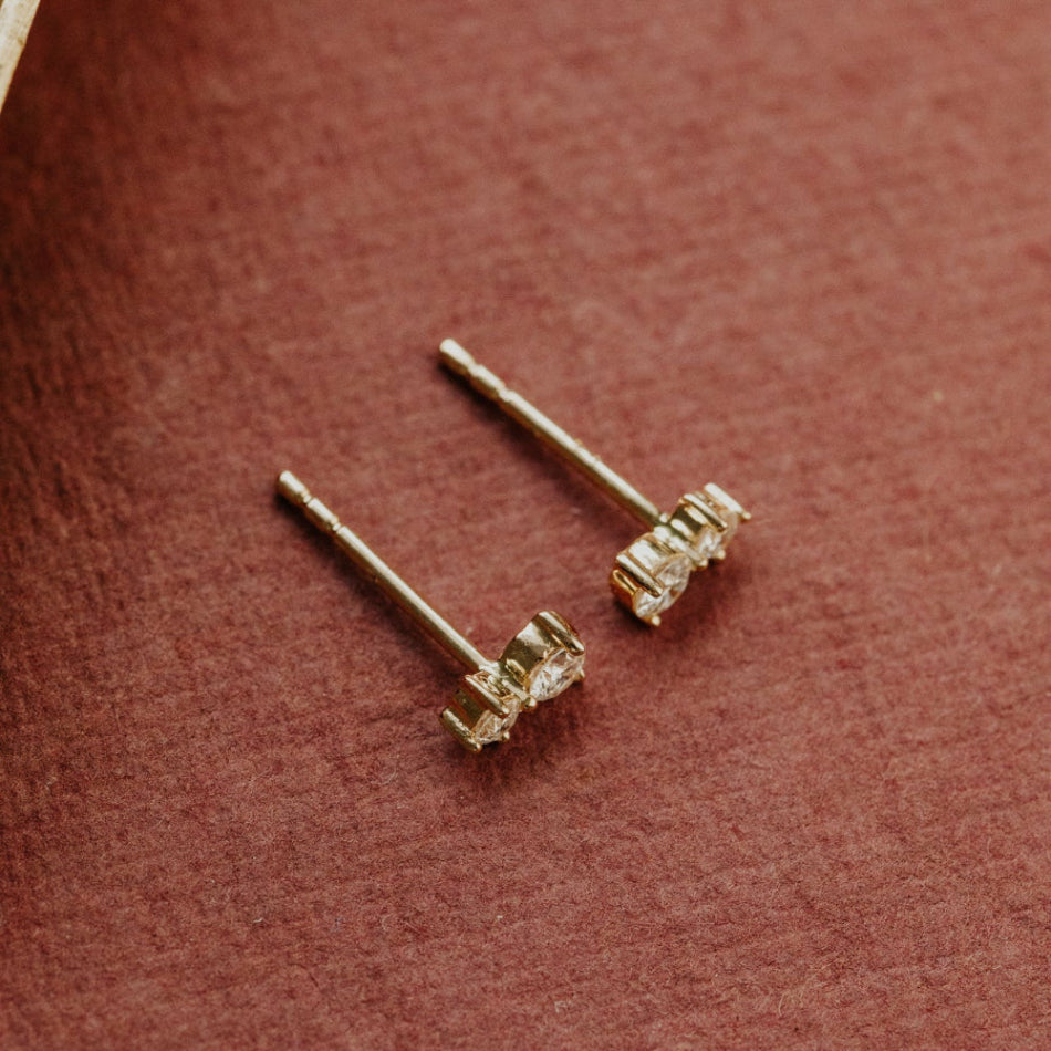 Gold earrings with diamonds on a brown surface