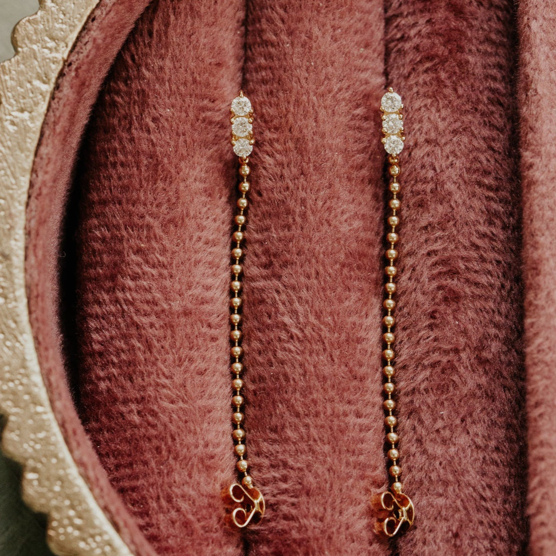 Two beaded necklaces on a textured pink surface
