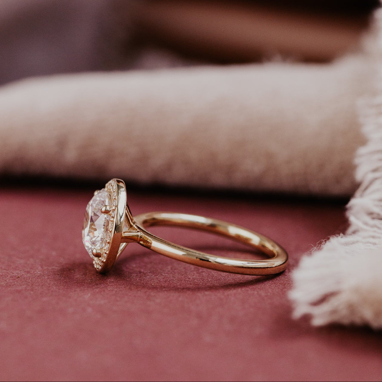 Rose gold ring with a round diamond on a textured surface
