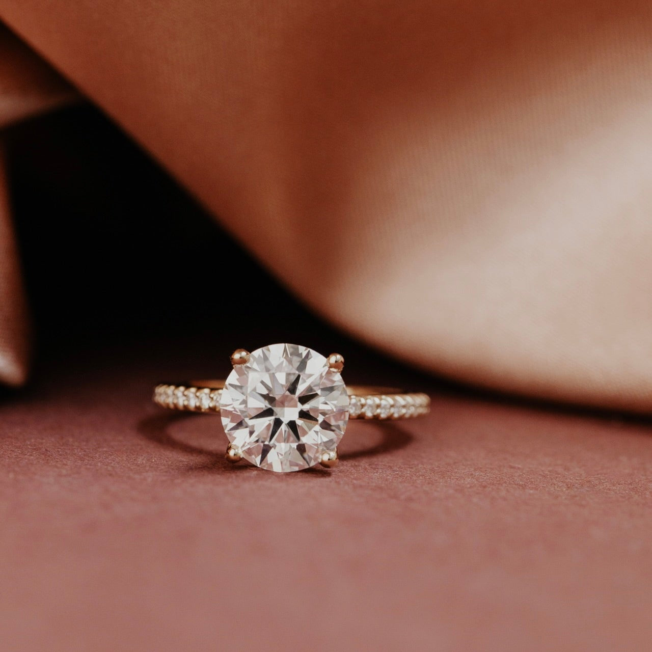 The Jenna Round Diamond Engagement Ring on a pave diamond band