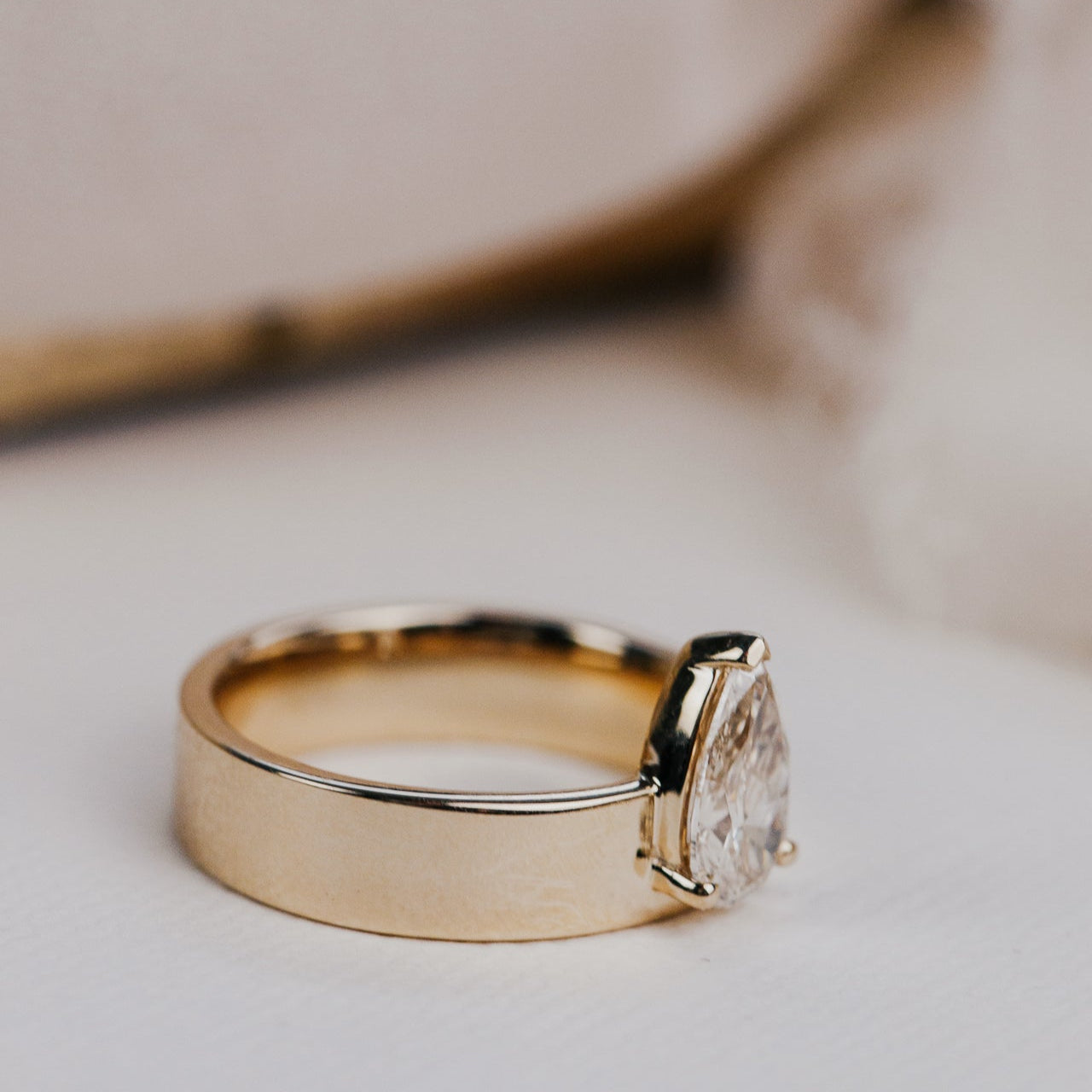 Gold ring with a champagne diamond on a light background