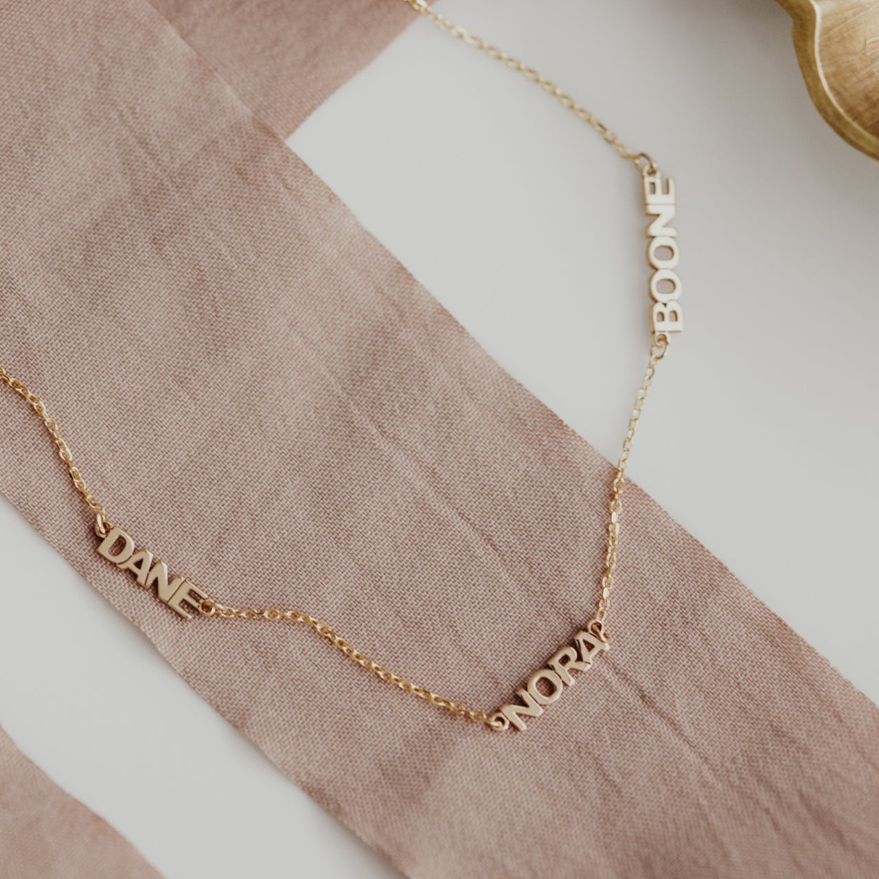 Personalized necklace with 3 custom names set on a 14k gold chain