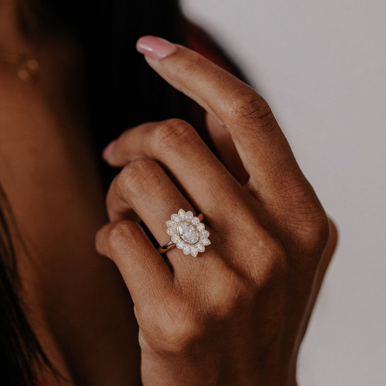 Hand wearing a diamond ring with a blurred background