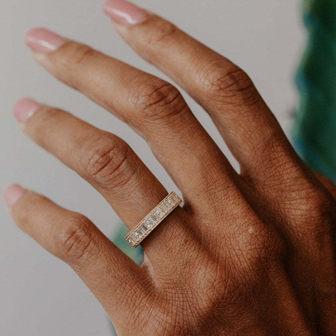Close-up of a hand wearing a diamond bandwith a blurred background