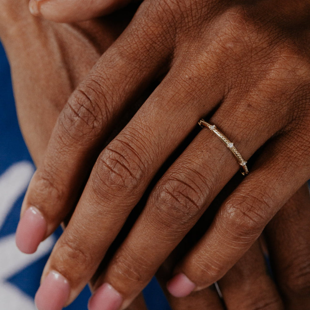 Close-up of hands with a gold ring on a blurred background