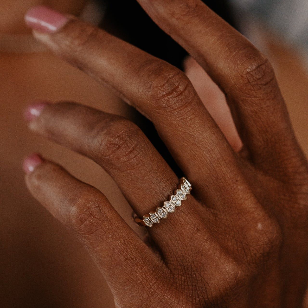 14k gold wedding band featuring round diamonds set in an elongated hexagon pattern.