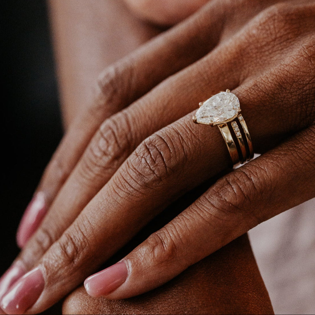 14k gold band featuring two stacked round pave bands with a total carat weight of ~.05 cttw paired with a pear diamond solitaire ring
