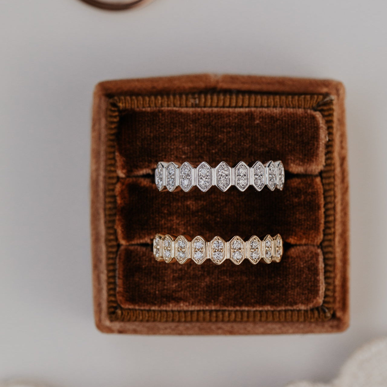 14k gold wedding band featuring round diamonds set in an elongated hexagon pattern.