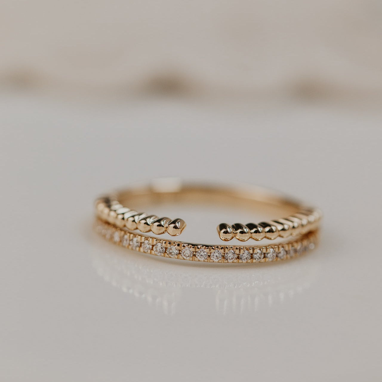 14k gold wedding band featuring a ~.10 cttw pave diamond band, with an open beaded texture band.