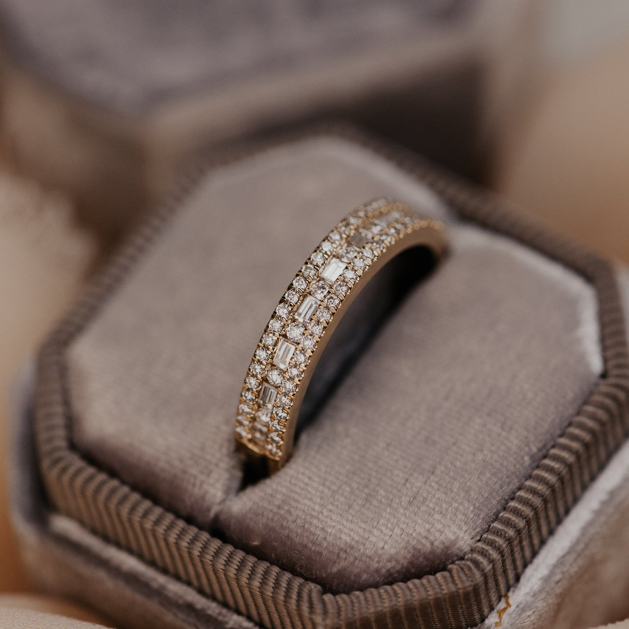14k gold wedding band with alternating horizontal baguette and round diamonds set between two rows of round pave diamonds.