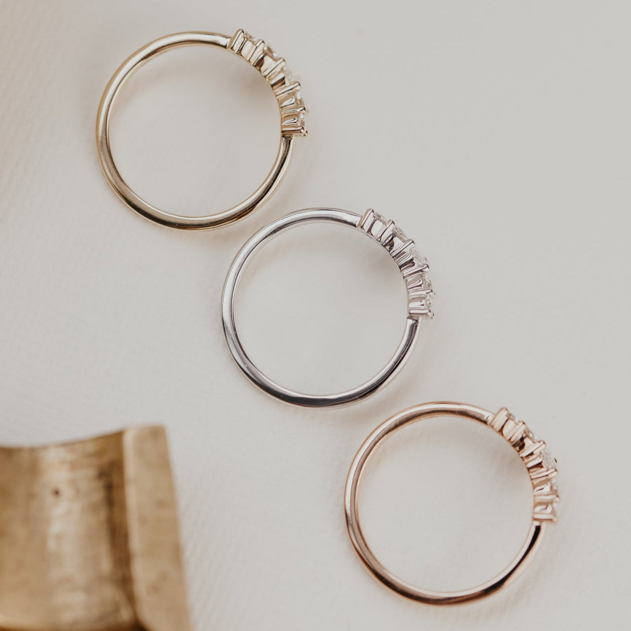 14k gold wedding band with round and oval diamonds, set in prongs in a starburst design.