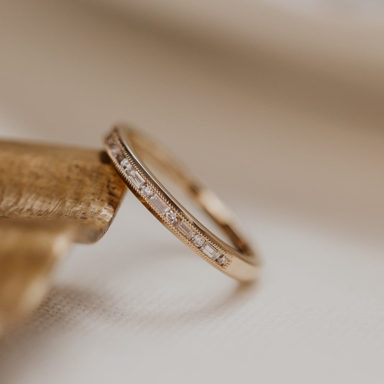 14k gold band  featuring ~ .22 cttw baguette and round diamonds set in milgrain detail edges.