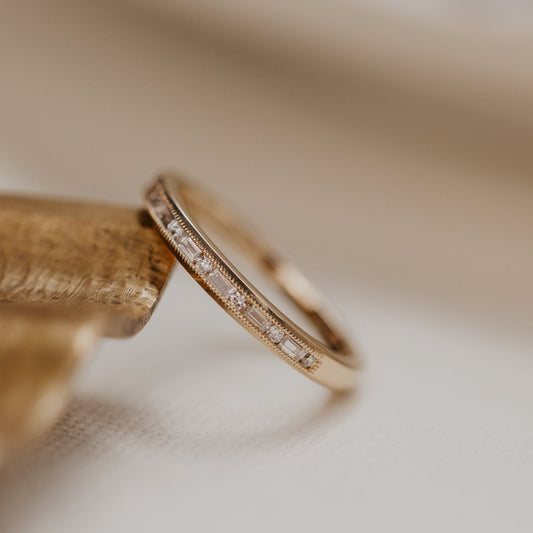 14k gold band  featuring ~ .22 cttw baguette and round diamonds set in milgrain detail edges.