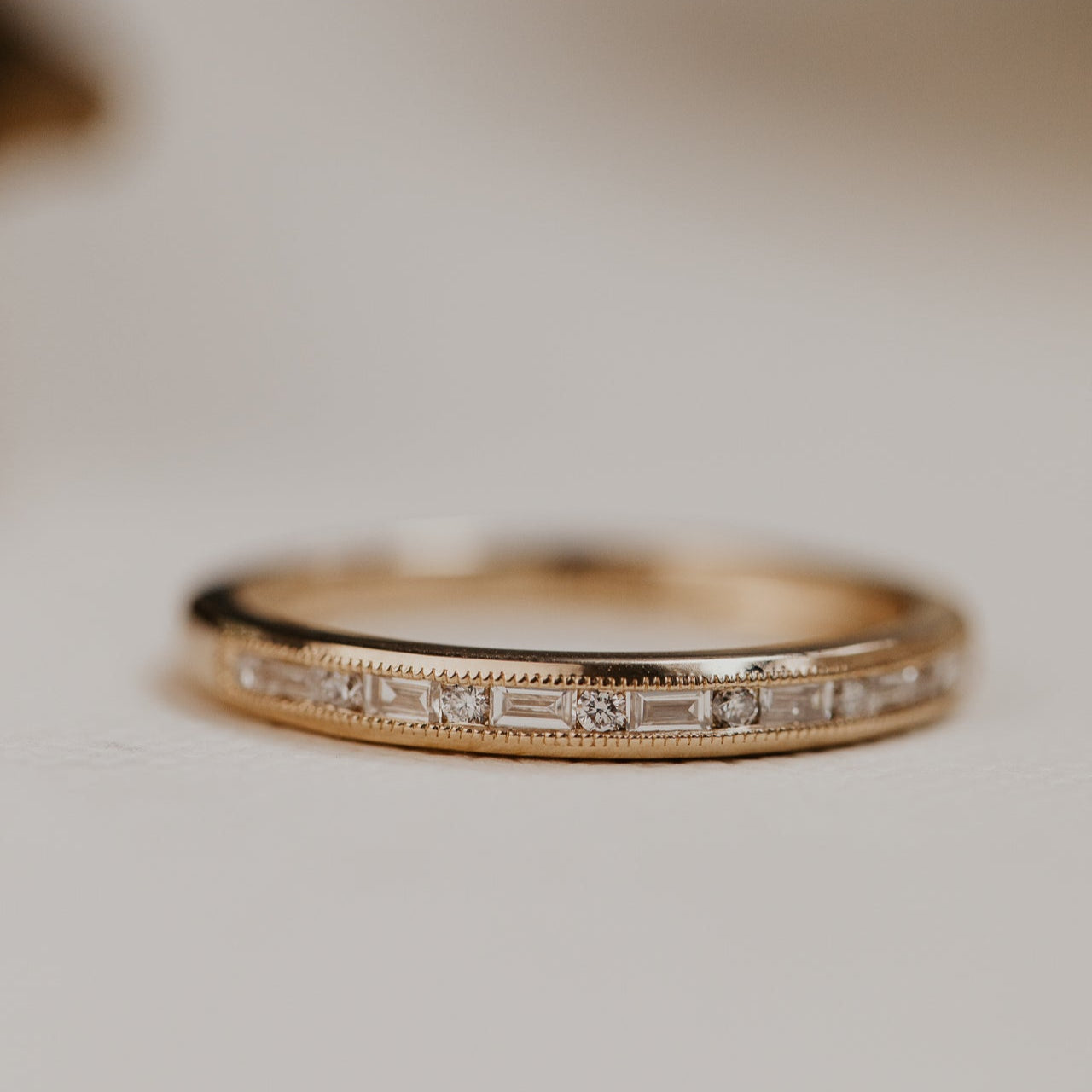 14k gold band featuring ~ .22 cttw baguette and round diamonds set in milgrain detail edges.