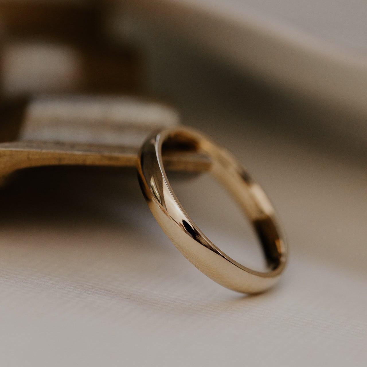 Gold ring on a wooden surface with a blurred background