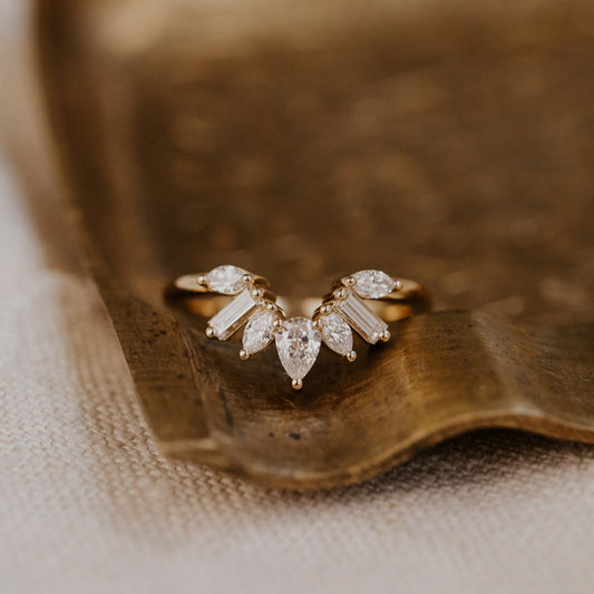 14k gold wedding band featuring pear, marquise, and baguette diamonds set in prongs in a starburst design.