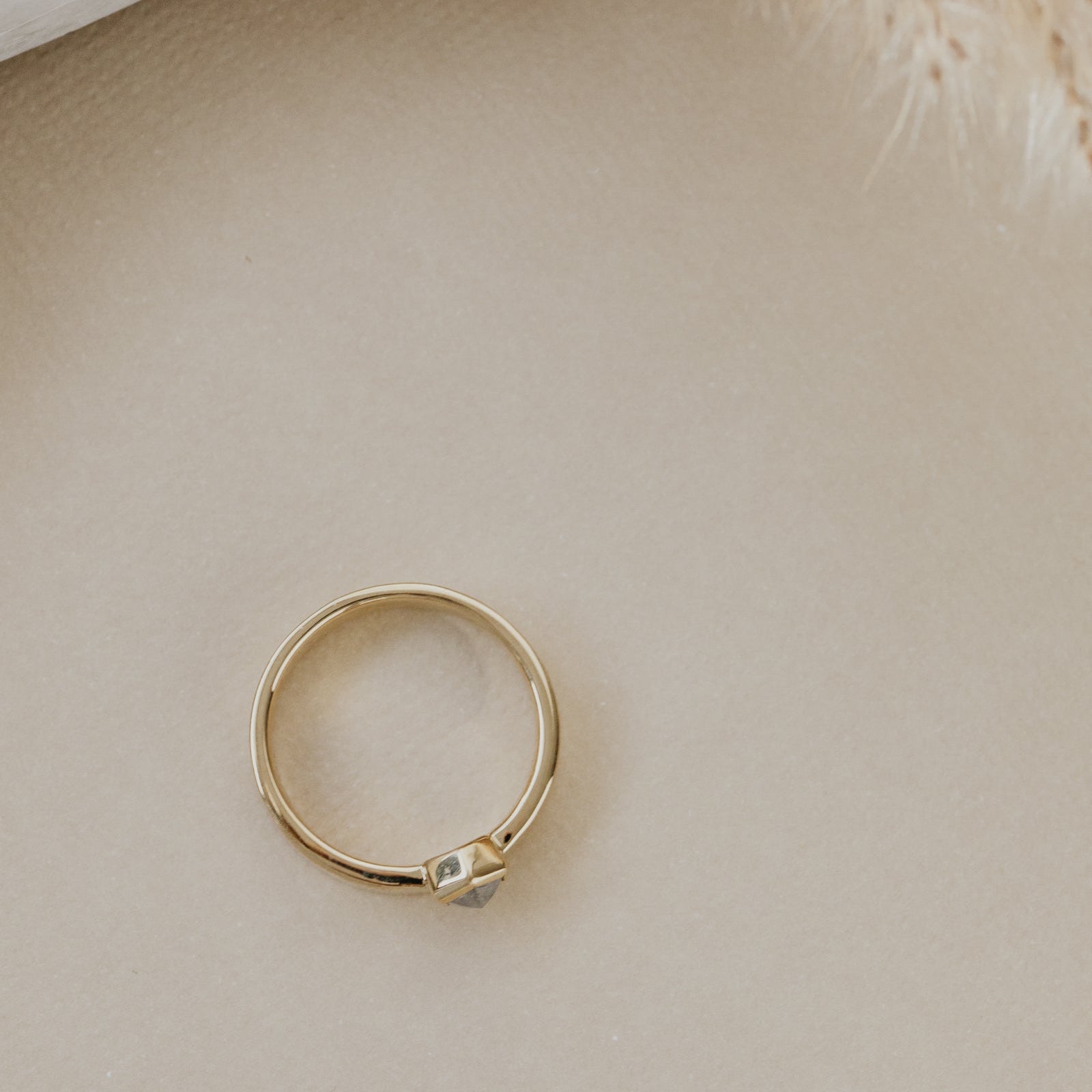 Gold ring on a beige surface.