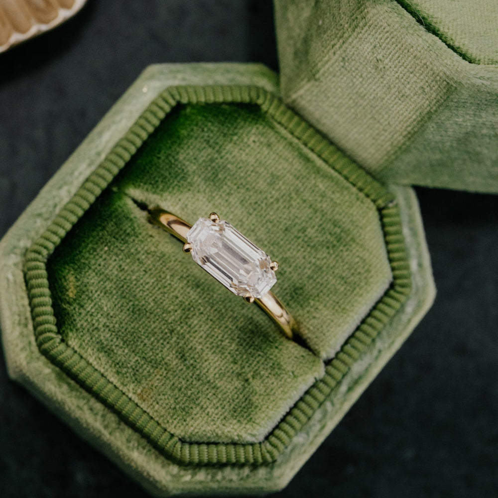 Lab grown diamond ring in a green velvet box on a dark surface.