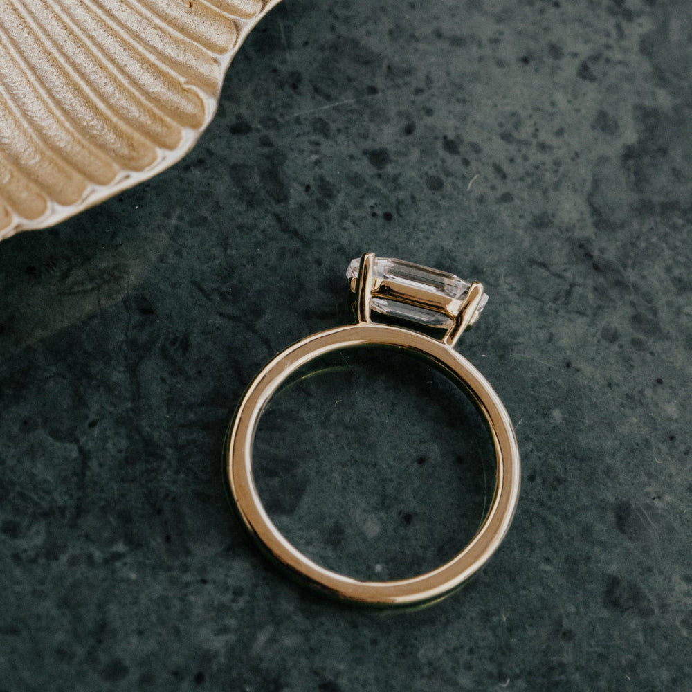 Gold ring with a diamond on a textured dark surface