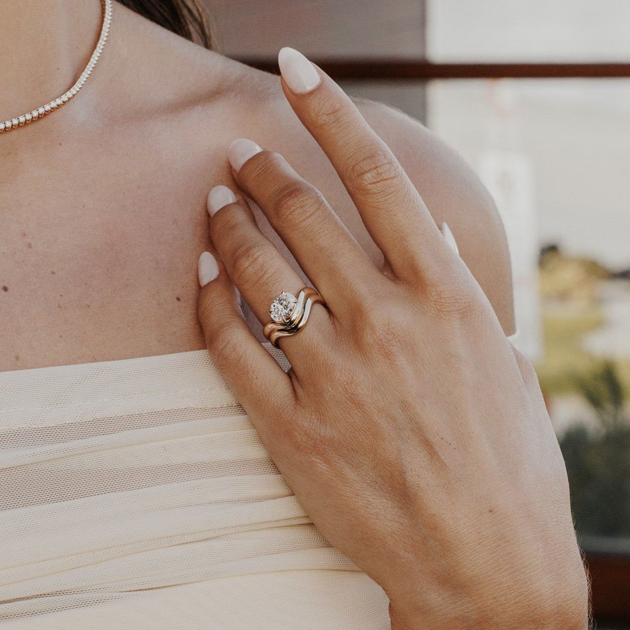 The Capri Oval Ring in 14k yellow gold featuring a lab-grown oval diamond prong set on a double wavy band, worn on the ring finger.