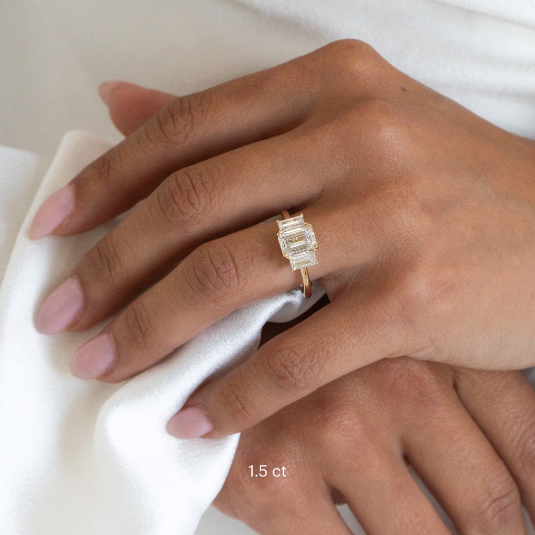 The Hannah Emerald Cut Ring in 14k yellow gold worn on the ring finger, shown in the 1.5 ct center stone size.