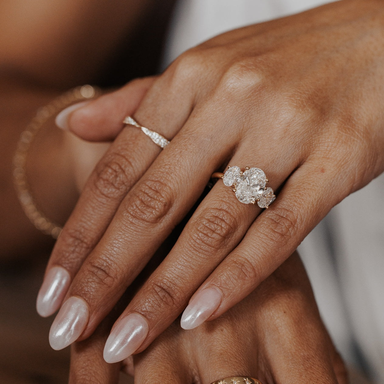 The Hannah Oval Ring in 14k yellow gold worn on the ring finger, styled with a diamond band on the index finger.