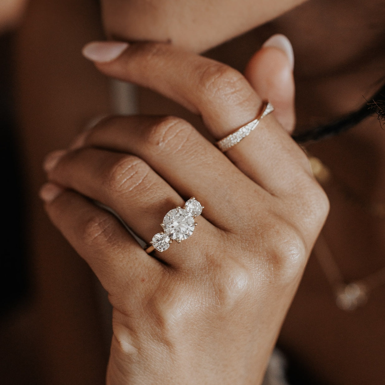 The Hannah Round Ring in 14k yellow gold worn on the ring finger, styled with a diamond eternity band on the index finger.
