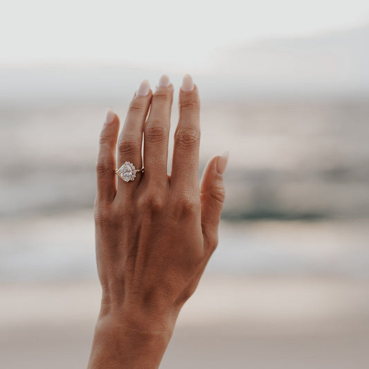 The Horizon Oval Ring in 14k yellow gold featuring a lab-grown oval diamond center stone with a round tapered diamond half halo, worn on the ring finger.