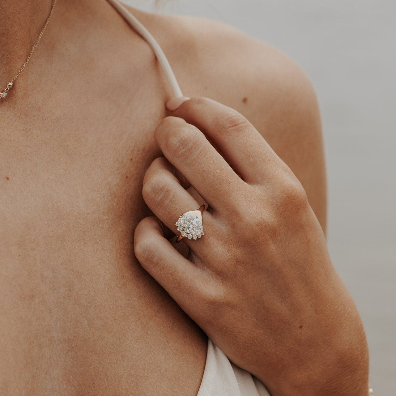 The Horizon Oval Ring in 14k yellow gold featuring a lab-grown oval diamond center stone with a round tapered diamond half halo, worn on the ring finger.