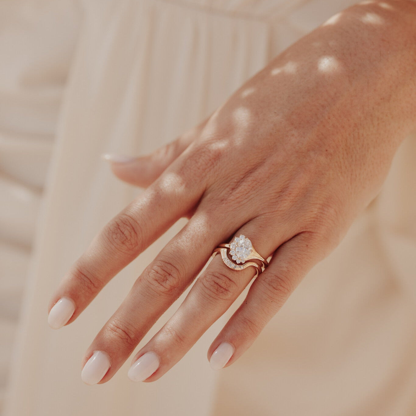 The Horizon Oval Ring in 14k yellow gold featuring a lab-grown oval diamond center stone with a round tapered diamond half halo, worn on the ring finger alongside a contoured gold band.