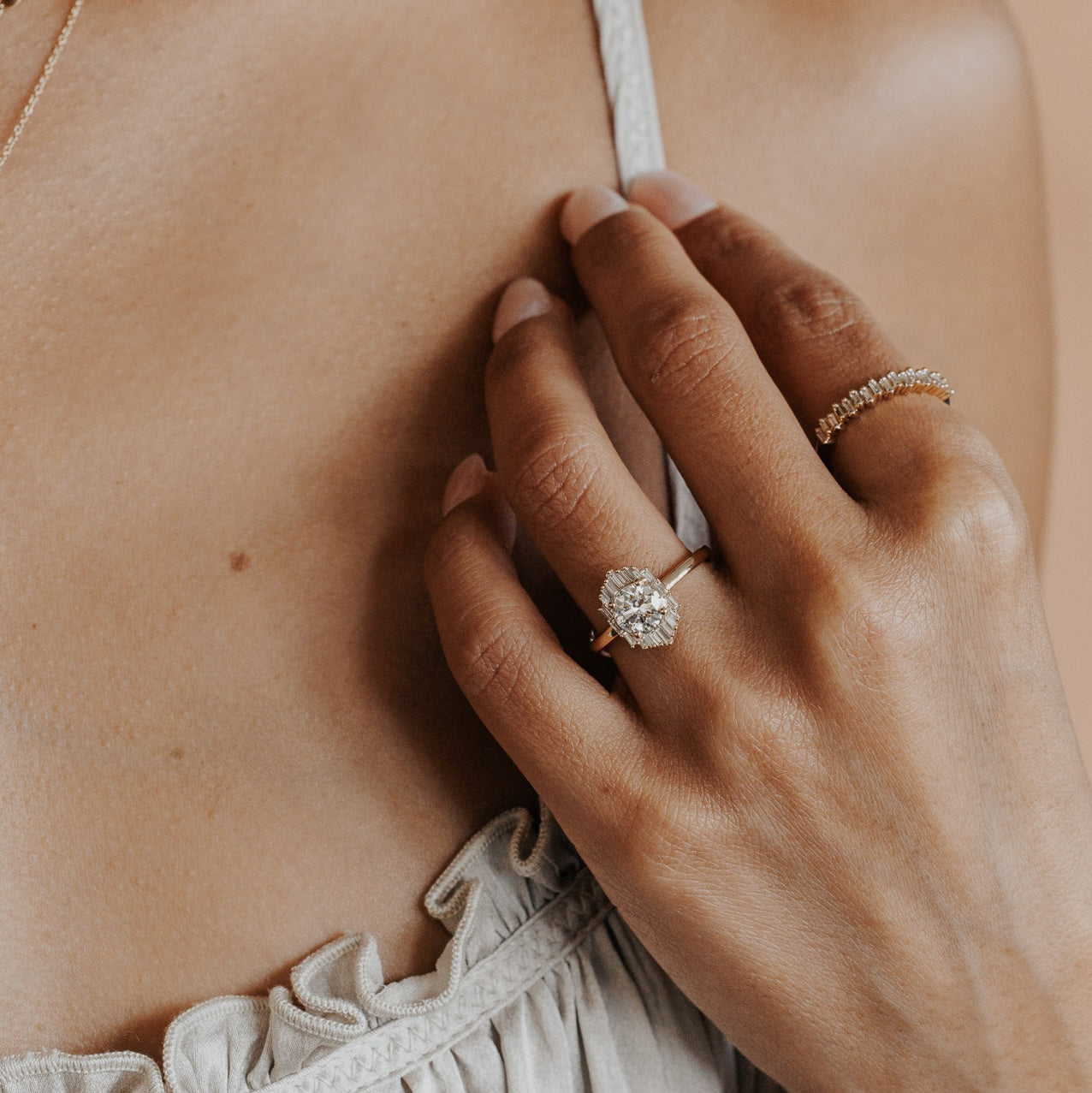 The North Star Ring in 14k yellow gold worn on the ring finger, styled with a baguette diamond band on the pointer finger.