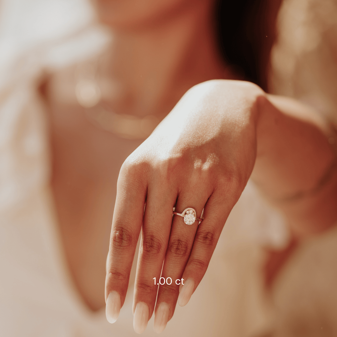 The Palma Round Ring in 14k yellow gold featuring a lab-grown round diamond center stone with round diamond arc accent, worn on the ring finger.