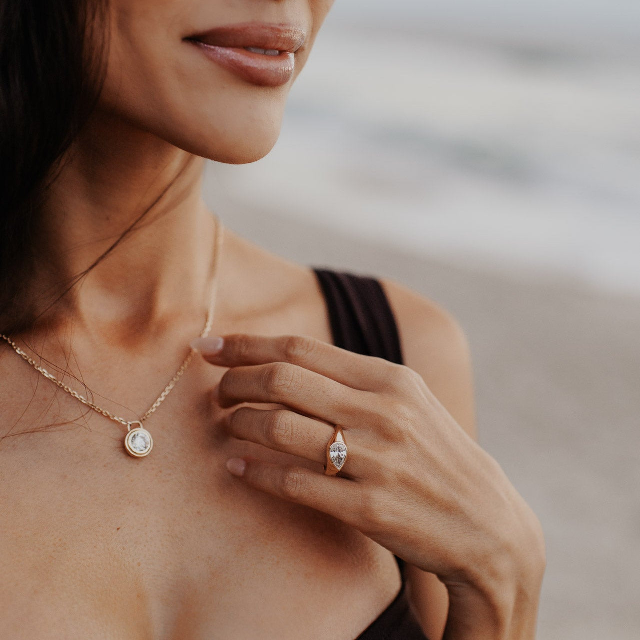 The Santorini Pear Ring in 14k yellow gold featuring a lab-grown pear diamond bezel set on a tapered band, worn on the ring finger.