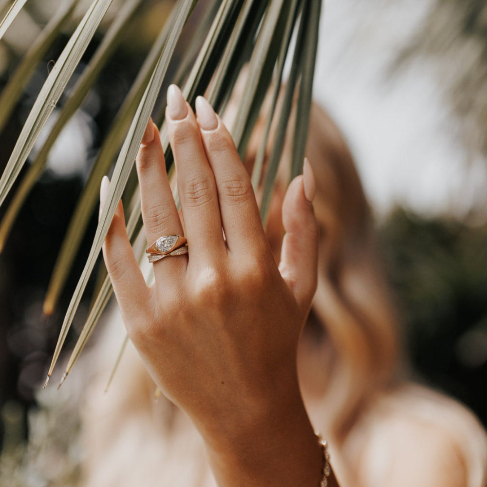 The Santorini Pear Ring in 14k yellow gold featuring a lab-grown pear diamond bezel set on a tapered band, styled with a diamond-pavé chevron band.