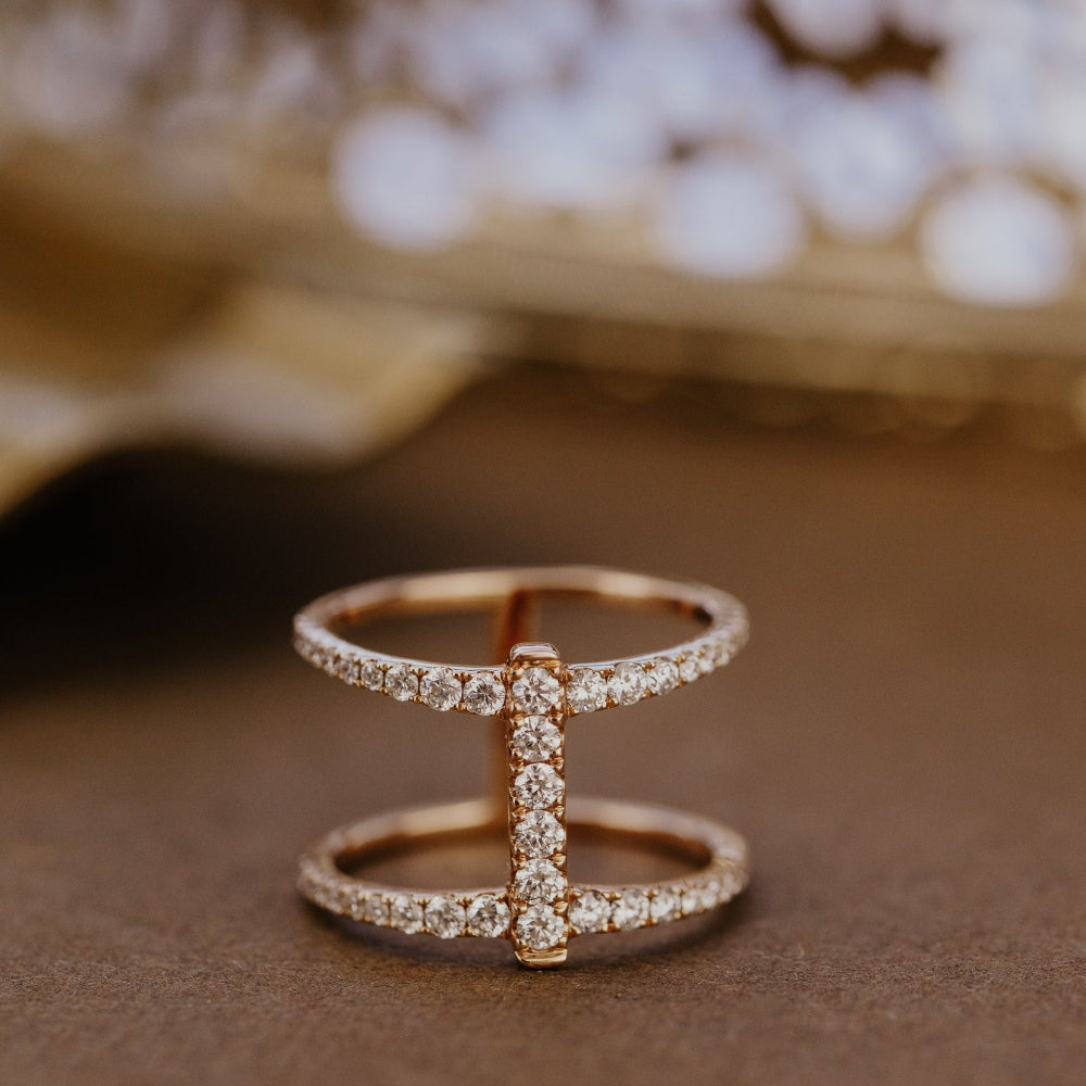 Rose gold wedding band with diamonds on a brown surface.