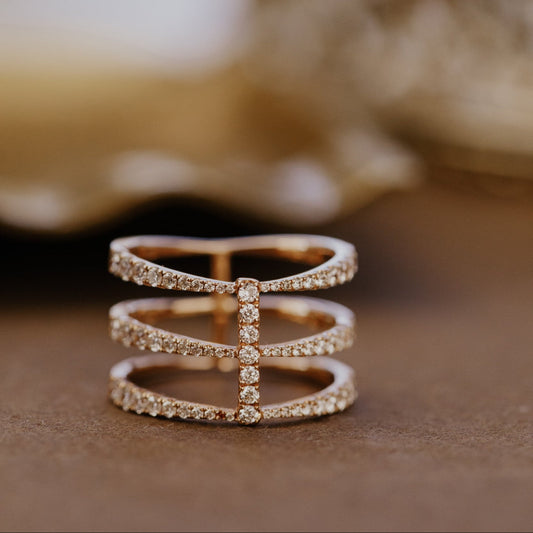 Rose gold wedding with three pave diamond bands on a textured surface.