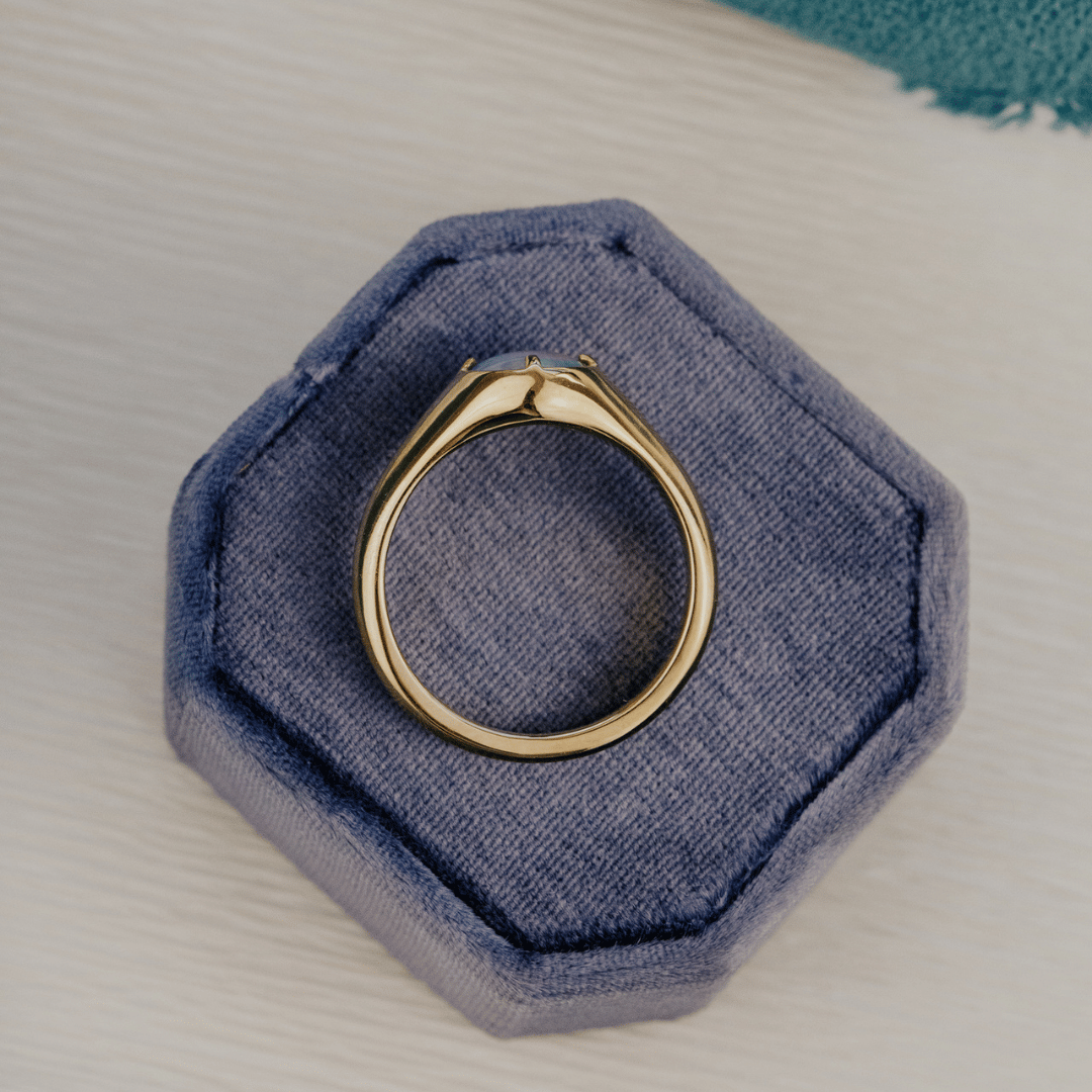 Opal triplet signet ring on velvet box. 