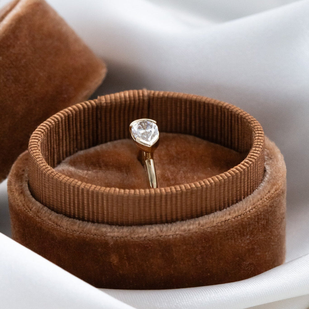 Austen diamond ring in a brown velvet ring box on a white background.