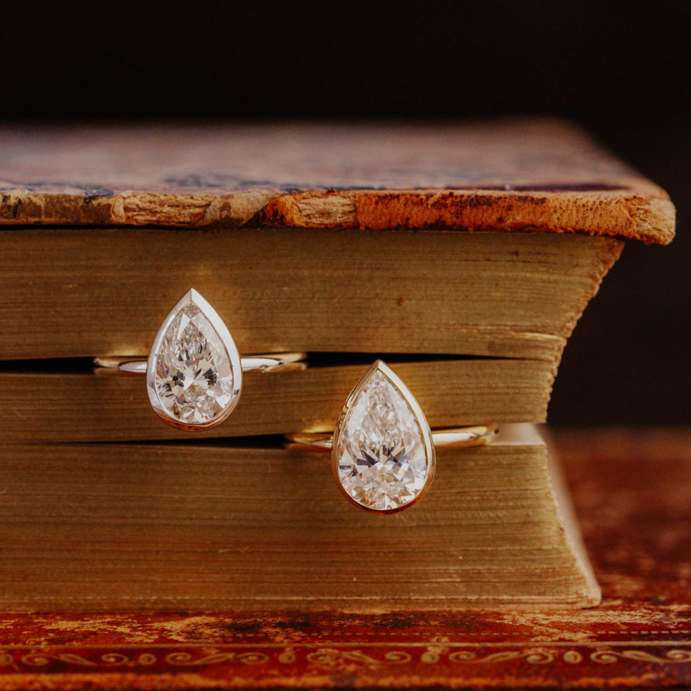 Bailey pear-shaped diamond earrings on an old book.