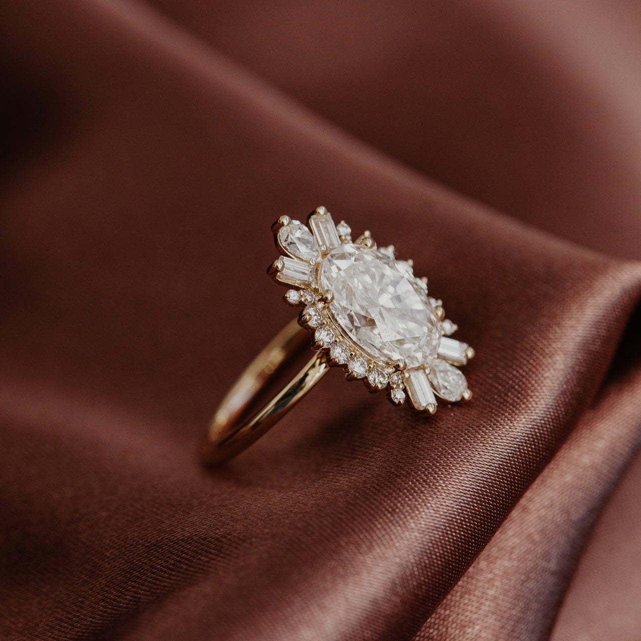 Profile view of The Celeste Oval Diamond Ring with a halo design in 14k yellow gold.