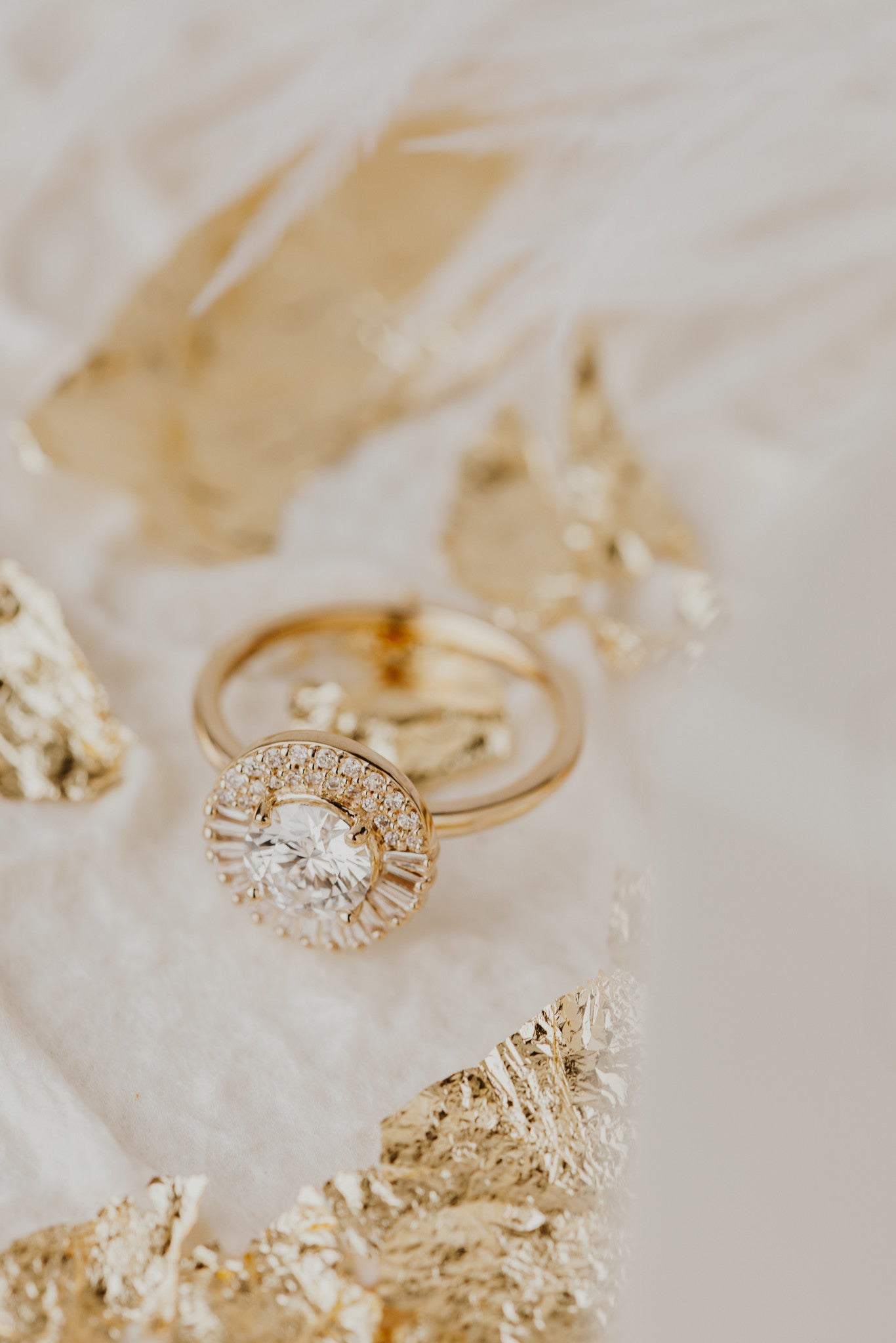 Florence round diamond engagement ring with a diamond halo on a white surface.