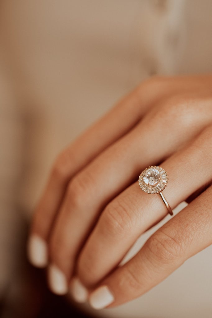 Close up of a hand wearing the Florence round diamond engagement ring.