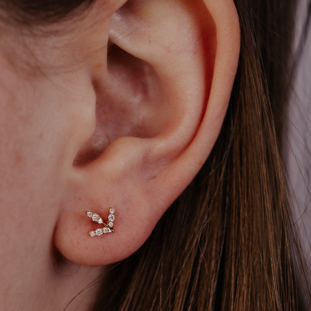 Close-up of an ear wearing a diamond stud earring.