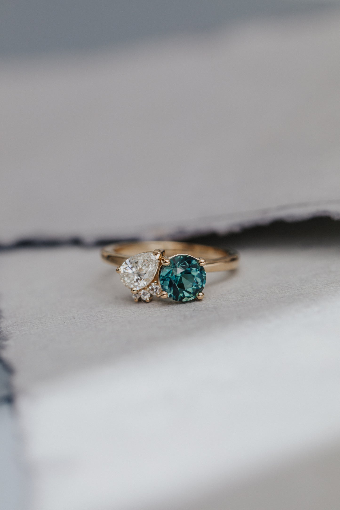 The Toi et Moi 1.70 ct Round Teal Sapphire and .50 ct Pear Diamond Ring