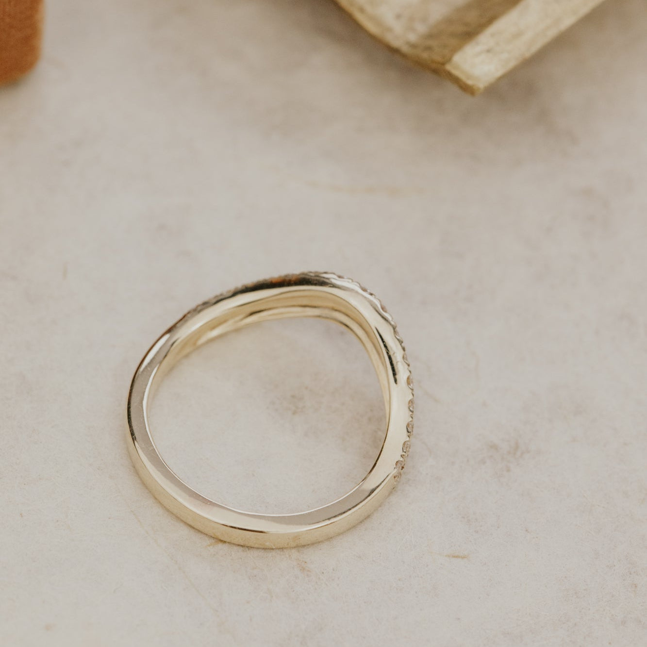 Gold Rose diamond tracer wedding on a textured beige surface.