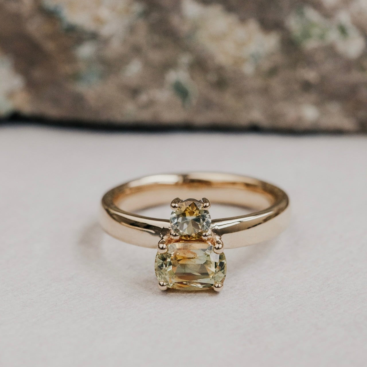 Gold ring with a green Montana sapphire gemstone on a neutral background