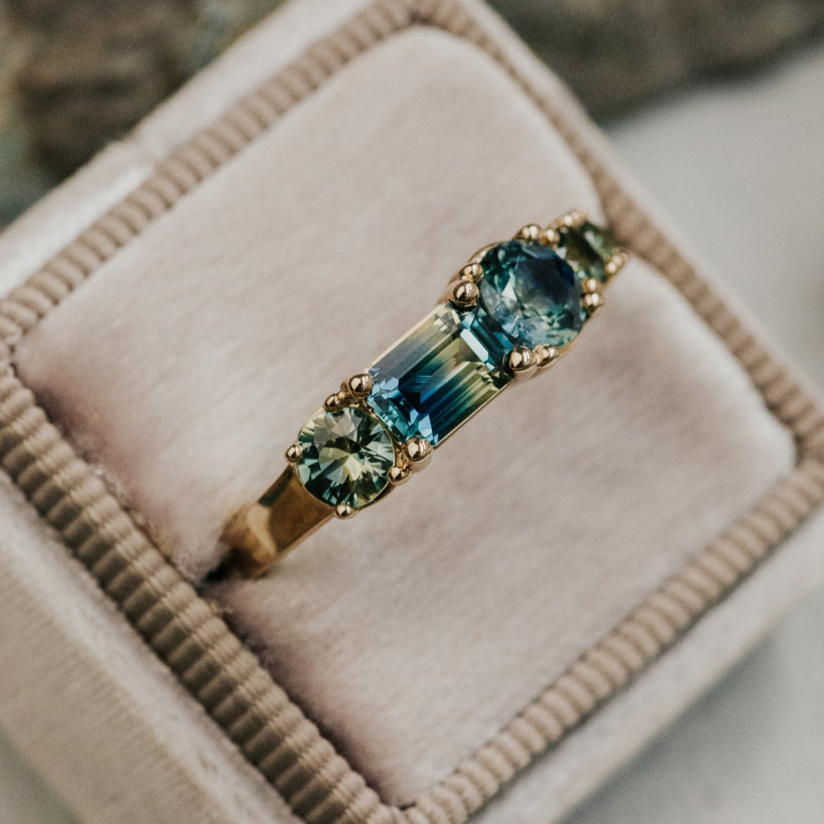 Gold ring with blue Australian sapphire gemstones in a pink jewelry box