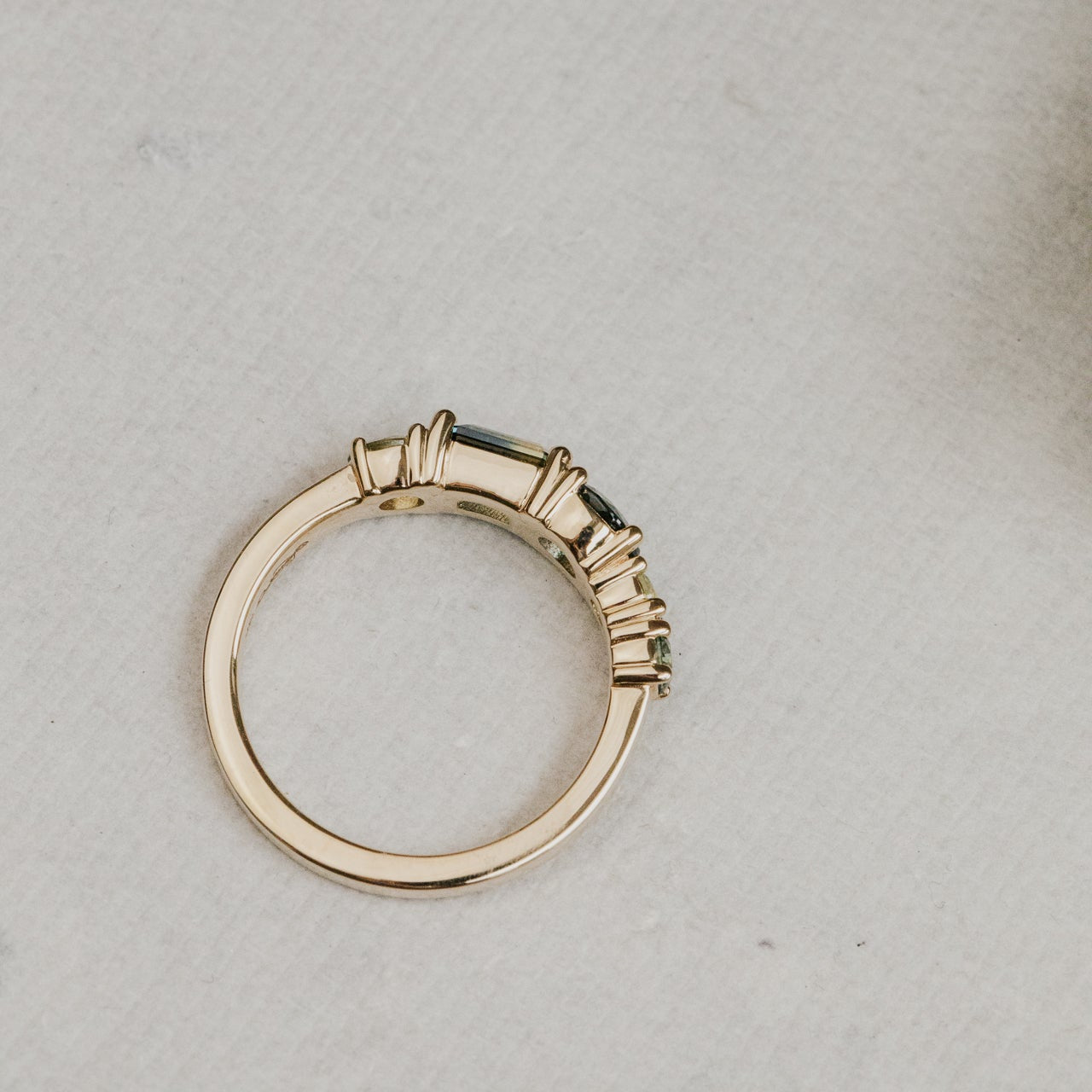 Gold ring with a stone on a textured gray surface