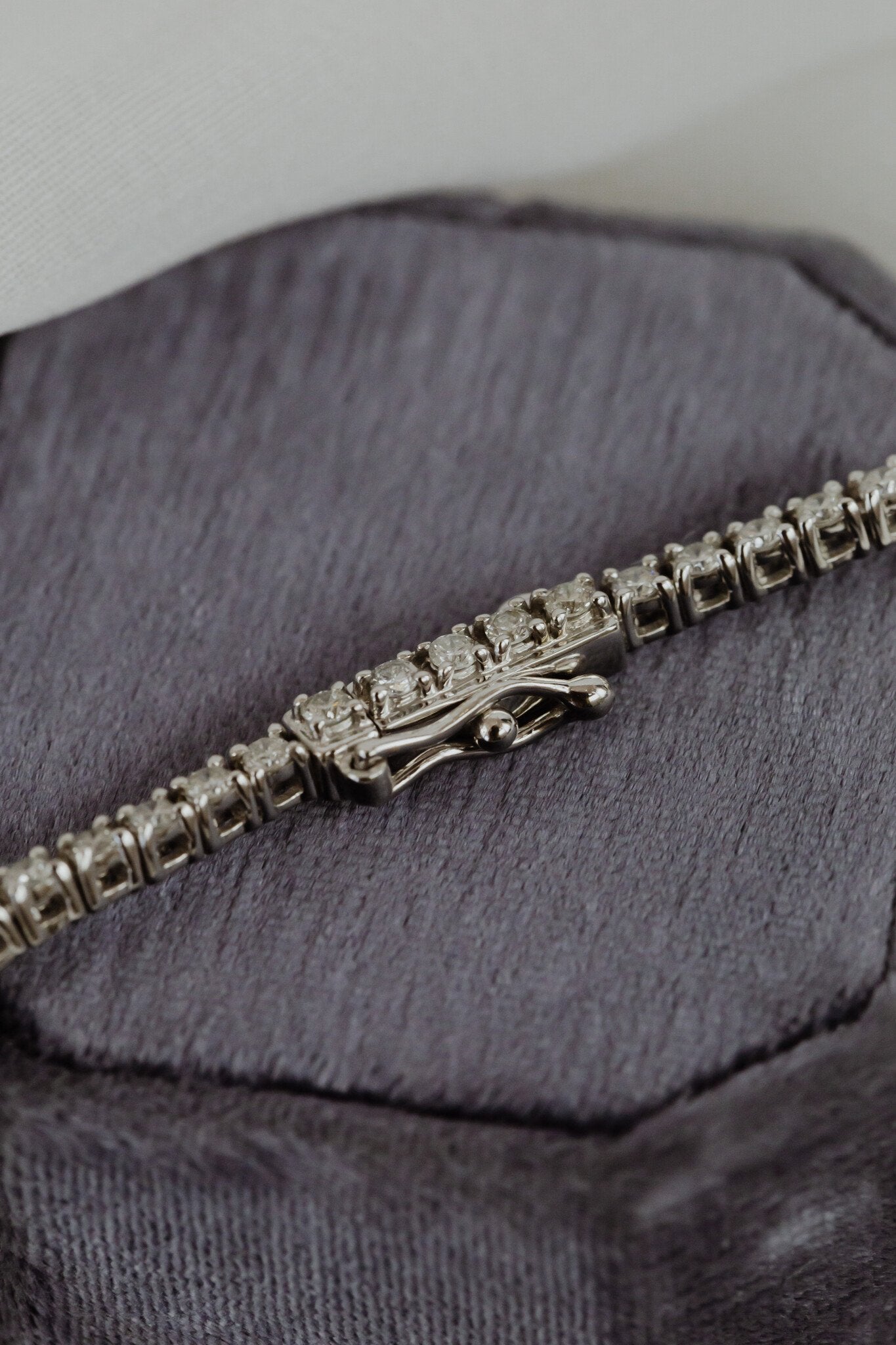 Close up the security clasp on a white gold diamond tennis bracelet.