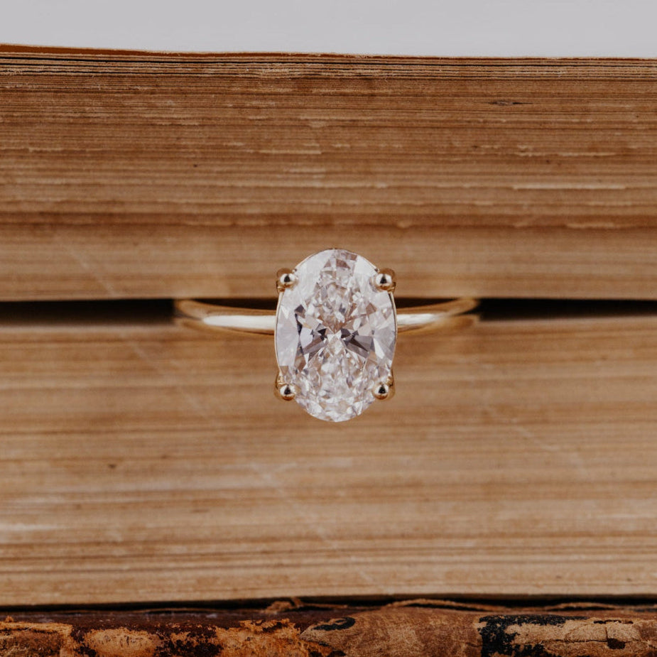 Oval diamond solitaire ring on an open book
